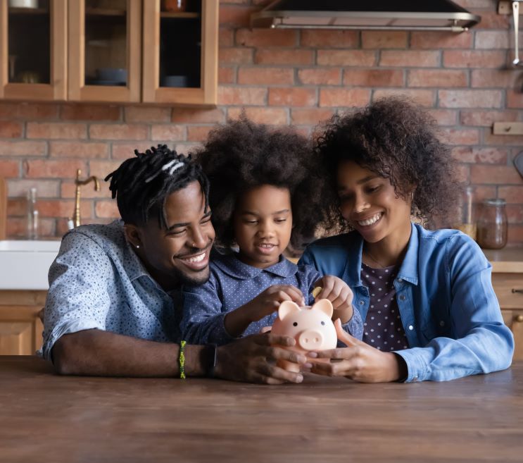 Smiling African American Family cradling a piggy bank